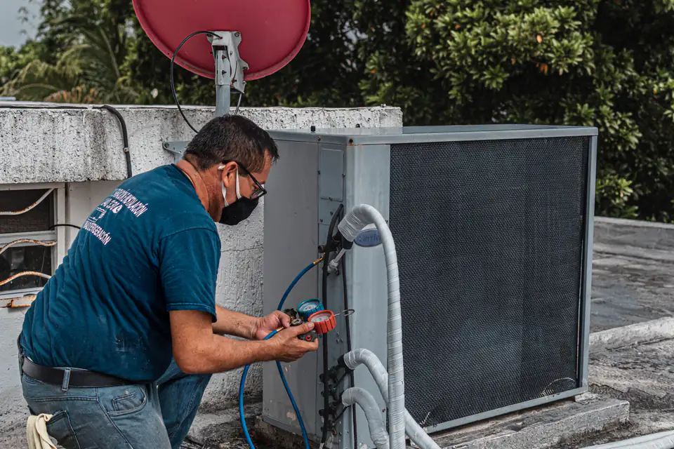 HVAC technician checking an outdoor air-conditioning unit
